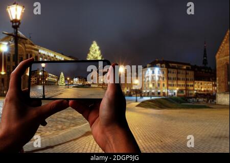 Il turista scatta la foto della piazza del Duomo con l'albero di Natale nella città vecchia di riga, riga, Lettonia Foto Stock
