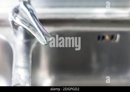 Vista dall'alto della leva del miscelatore di un rubinetto a cascata cromato di una cucina domestica con il lavello in alluminio sullo sfondo. Calcare sulla leva Foto Stock