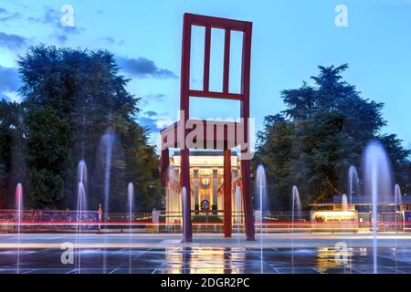 Scena notturna in Place des Nations a Ginevra, Svizzera, con il monumento alla sedia rotta e l'ingresso principale del capo europeo delle Nazioni Unite Foto Stock