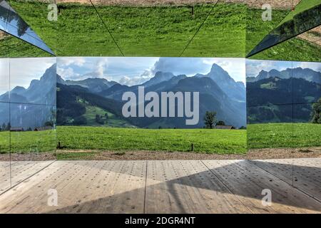 Gstaad, Svizzera - 15 agosto 2020 - Paesaggio delle Alpi svizzere specchiato dalle mura del Mirage, istalazione artistica temporanea di Doug Aitken cons Foto Stock