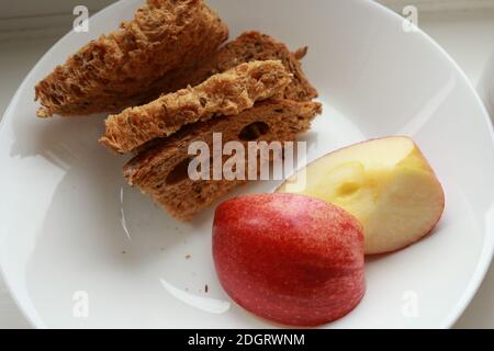 Basso indice glicemico Pane marrone da colazione con fetta di mele su piatto bianco Foto Stock