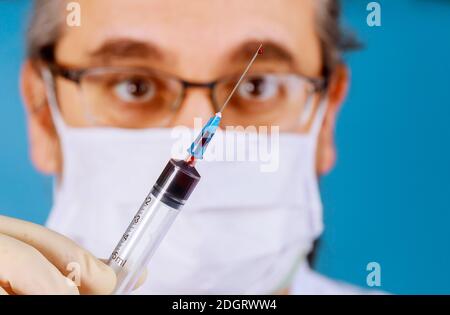 Il medico prende a mano una provetta per campioni di sangue con l'analisi Foto Stock