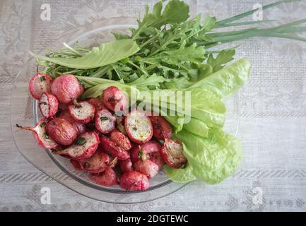 Rafano cotti al forno con le cipolle verdi e insalata. Foto Stock