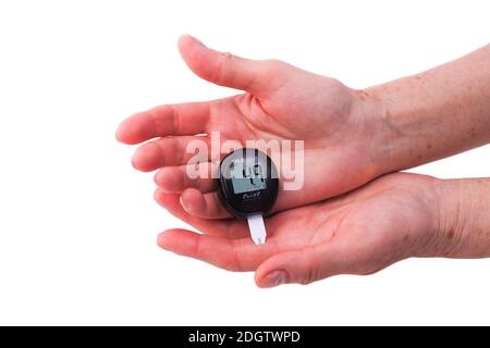 Le mani di una donna anziana che analizza la glicemia Foto Stock