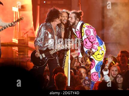 Post Malone (a destra) suona con Joe Perry (a sinistra) e Steven Tyler di Aerosmith sul palco dell'MTV Video Music Awards 2018, radio City, New York. Il credito fotografico dovrebbe essere: Doug Peters/EMPICS Foto Stock
