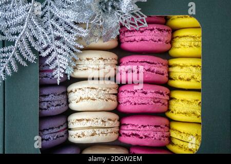 Macaroni colorati e deliziosi di fila. I biscotti colorati di macaron sono in una scatola di regalo. Sfondo, primo piano, messa a fuoco selettiva. Foto Stock