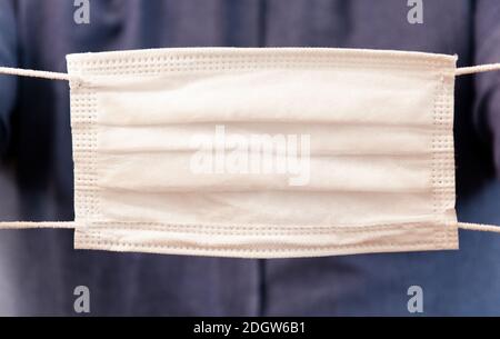 L'uomo sta mostrando una maschera protettiva. Foto Stock