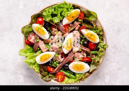 Insalata francese Nicoise con tonno, uova, fagioli verdi, pomodori, olive, lattuga e acciughe. Foto Stock