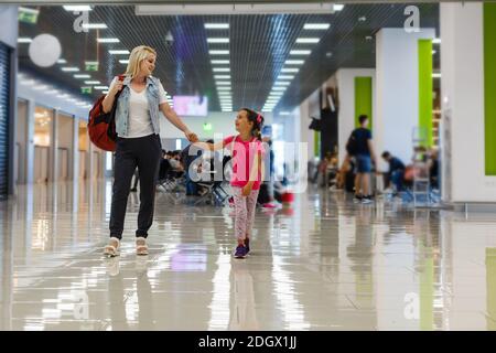 Felice madre e figlia giocando una partita in aeroporto prima dell'imbarco Foto Stock