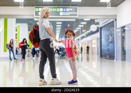 Felice madre e figlia giocando una partita in aeroporto prima dell'imbarco Foto Stock