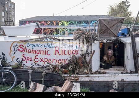 Locale sulla sua casa galleggiante nella valle di Lea, Hackney, alloggi poveri, barca fluviale, condizioni sociali, affari, hippy, Londra orientale, Regno Unito Foto Stock