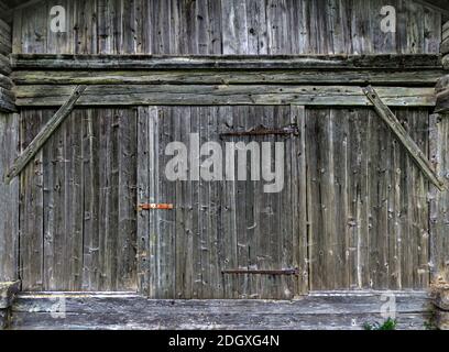 Facciata in legno intemperie con porta di un vecchio fienile in Tirolo, Austria Foto Stock