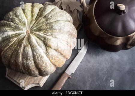 Una zucca grande vicino ad un vaso di ceramica Foto Stock