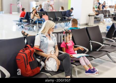 Felice madre e figlia giocando una partita in aeroporto prima dell'imbarco Foto Stock