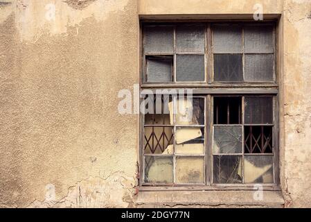 Vecchia casa gialla abbandonata distrutta con le finestre scomposte Foto Stock