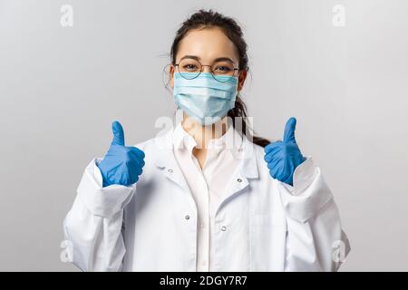 Dottori, infettisti, ricerca e concetto19. Soddisfatto giovane medico asiatico femmina ricevere buoni risultati sullo studio del virus, Foto Stock