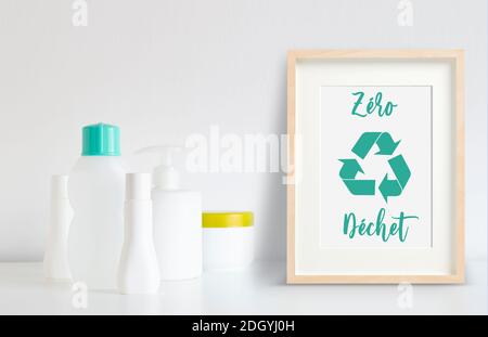 Alcune bottiglie di plastica pronte per essere riciclate accanto a una cornice con logo di riciclo e messaggio di zero rifiuti in francese. Foto Stock