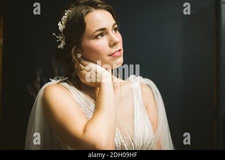 Bella sposa giovane prima della cerimonia nuziale. Preparazione della sposa. Matrimonio mattina. Affascinante sposa in bianco abito da sposa a. Foto Stock