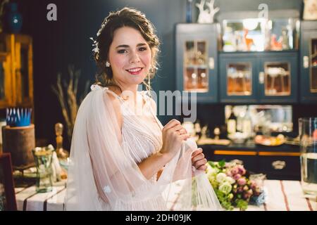 Bella sposa giovane prima della cerimonia nuziale. Preparazione della sposa. Matrimonio mattina. Affascinante sposa in bianco abito da sposa a. Foto Stock