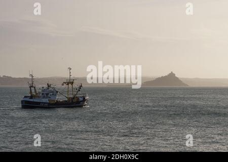 Barca da pesca che lascia il porto di Newlyn Penzance Cornwall. Passando per St Michael's Mount a Mount's Bay, Regno Unito Foto Stock