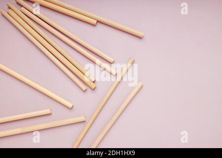 Cannucce di bambù riutilizzabili su sfondo rosa, utensili ecologici Foto Stock
