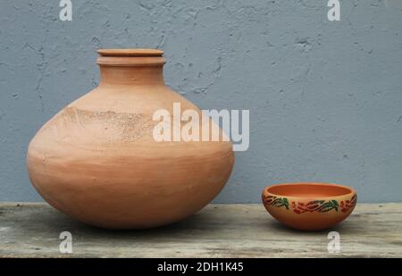 Caraffa contenente acqua su una tavola di legno con sfondo grigio Foto Stock