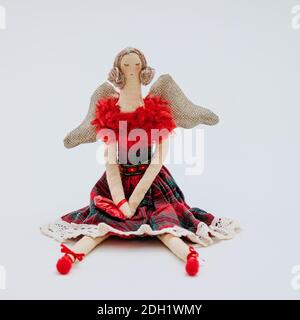 Un morbido giocattolo natalizio a forma di elegante ballerina in abito rosso con gonna a scacchi Foto Stock