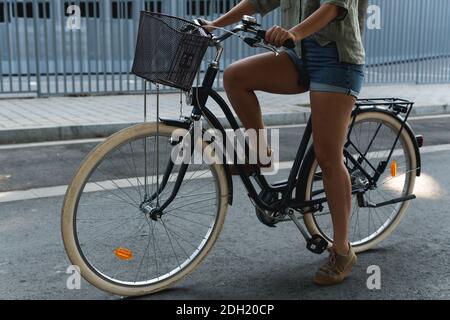 Giovane ragazza seduta sulla sua bici hipster in una città impostazione Foto Stock