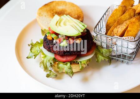 Hamburger vegani con barbabietole e fagioli serviti con verdure fresche. Foto Stock