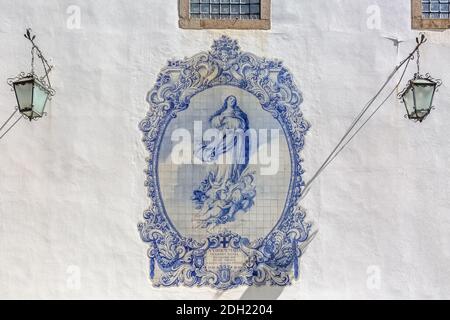 Guimaraes / Portogallo - 12 09 2020 : Collezione tradizionale di pannelli in piastrelle, dipinti con Vergine Maria con Angeli, su parete bianca facciata edificio, finestre e Foto Stock
