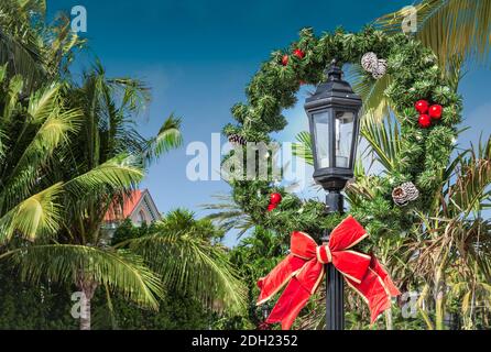 Decorazione della corona di Natale su un palo della lampada di strada a Key West, Florida. Foto Stock