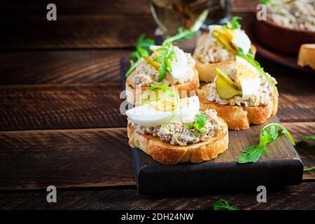 Pane tostato con mousse di merluzzo salato su tagliere di legno. Pasta di sgombro su tostature di pane fritto. Cucina scandinava Foto Stock