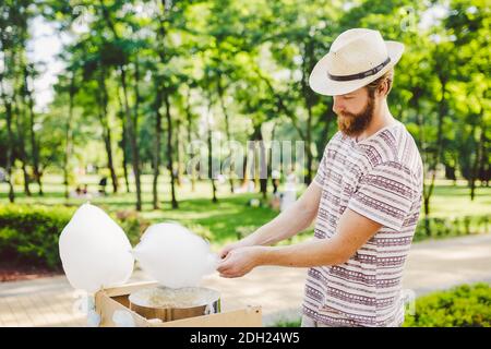 Foto tema piccole imprese che cucinano dolci. Un giovane con una barba di un commerciante caucasico nel cappello il proprietario del mak outlet Foto Stock