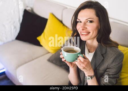 Allegro esperto vita di mezza età o allenatore di affari godendo processo creativo di fare nuovo testo, seduto al posto di lavoro, scrittura Foto Stock