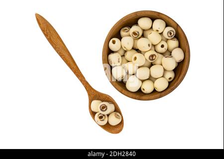Semi di loto secchi in ciotola di legno e cucchiaio di legno su sfondo bianco con percorso di ritaglio. Foto Stock