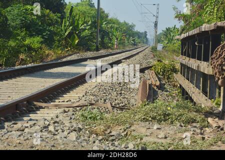 Primo piano di linee ferroviarie, binari ferroviari, ferrovia di Indian Railway con ringhiere ferroviarie, pietre su una ferrovia che attraversa una strada, focalizzazione selettiva Foto Stock