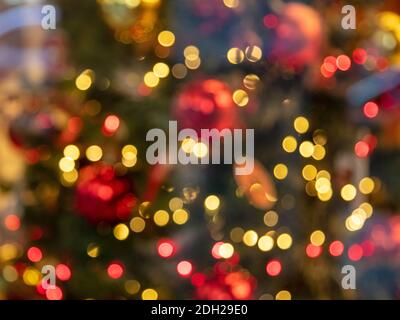 Luci di Natale sfondo bokeh colorato. Festa festiva celebrazione evento decorazione. Albero di Natale in uno schermo del negozio, sfocato vista dietro Foto Stock