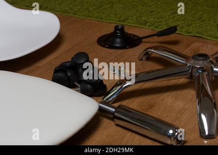 Dettagli della sedia da ufficio. Si trovano al piano dell'appartamento. Montaggio di una sedia per computer su ruote. Foto Stock