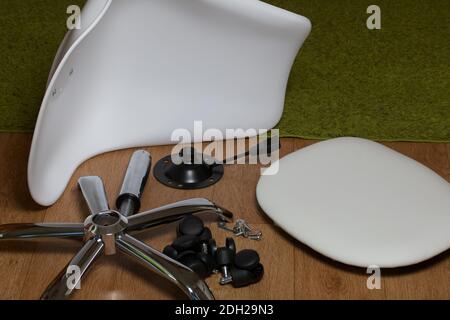 Dettagli della sedia da ufficio. Si trovano al piano dell'appartamento. Montaggio di una sedia per computer su ruote. Foto Stock