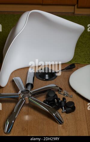 Dettagli della sedia da ufficio. Si trovano al piano dell'appartamento. Montaggio di una sedia per computer su ruote. Foto Stock