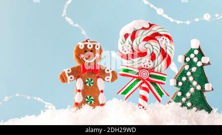 Natale Lollipop, albero di Natale, zenzero nella neve su sfondo blu. Spazio di copia. Sfondo di Natale. Foto Stock