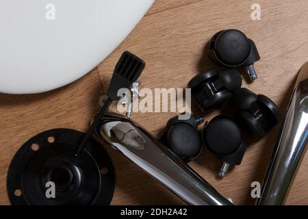 Dettagli della sedia da ufficio. Si trovano al piano dell'appartamento. Montaggio di una sedia per computer su ruote. Primo piano. Foto Stock