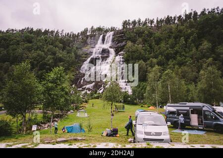Tvinde Campeggio tende sullo sfondo di una cascata Tvindefossen in Norvegia vicino a Voss. Campeggio nei fiordi norvegesi Foto Stock