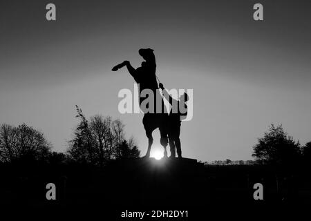 Alba sulla statua di Newmarket Stallion di Marcia Astor e Allan Sly, all'ippodromo di Newmarket, Suffolk, Inghilterra, Regno Unito Foto Stock