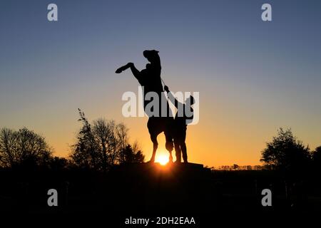 Alba sulla statua di Newmarket Stallion di Marcia Astor e Allan Sly, all'ippodromo di Newmarket, Suffolk, Inghilterra, Regno Unito Foto Stock