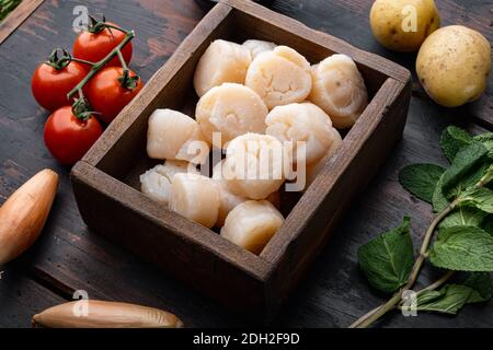 Capesante crude fresche ingredienti pronti per la cottura, su fondo di legno scuro Foto Stock