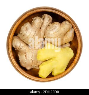 Radici fresche di zenzero, sbucciate e sbucciate, in una ciotola di legno. Rizomi di Zingiber officinale, usati come spezie profumate e come medicina popolare. Foto Stock