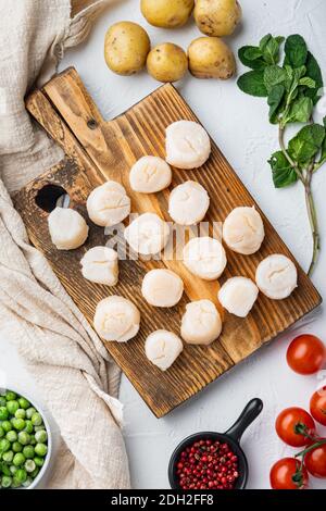 Prelibatezze di mare, capesante con patate, piselli verdi e menta, vista dall'alto, su sfondo bianco Foto Stock