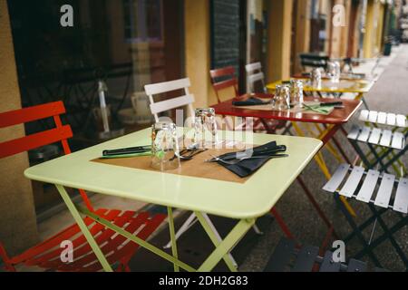 Caffè a tema e ristoranti. Terrazza esterna estiva dai colori luminosi della caffetteria di strada in Europa in Francia. Tabelle conservate Foto Stock