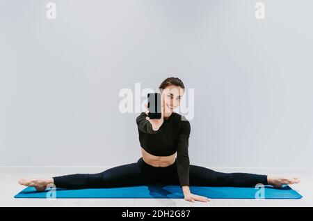 Bella ragazza allenarsi in palestra. Ballerina russa classica che fa stretching e yoga pone Foto Stock